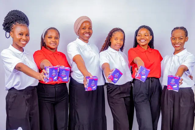 Six Her Essence volunteers holding up sanitary towel packs