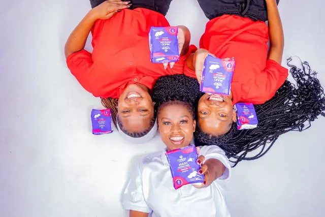 Her Essence volunteers photographed from above holding sanitary pads